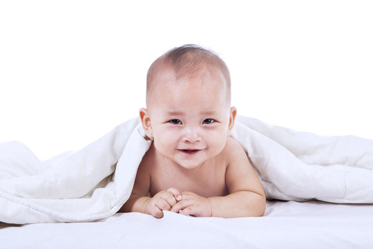 Cute baby laughing under blanket
