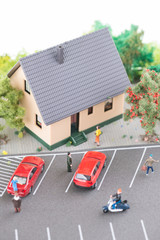 Miniature people, town house and a busy street model top view