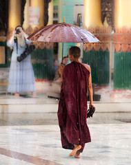 Yangon. Shwedagon Pagoda, monks pray at the foot of deities © seqoya
