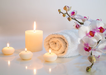 preparation for bath in white with towels, candles and orchid