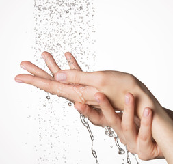 Closeup female hands under the stream of splashing water