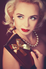 Pretty blond girl model like Marilyn Monroe with gift