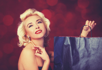 Pretty blond girl model like Marilyn Monroe with shopping bag