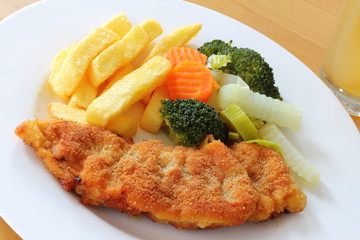 Paniertes Schweineschnitzel mit Pommes frites und Gemüse