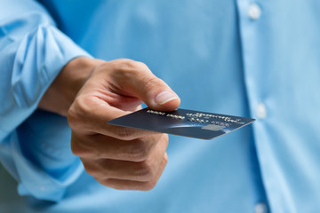Closeup of hand holding and giving credit card for payment