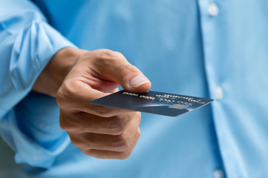 Closeup Of Hand Holding And Giving Credit Card For Payment