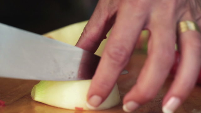 Female hands with knife, cutting fresh onion