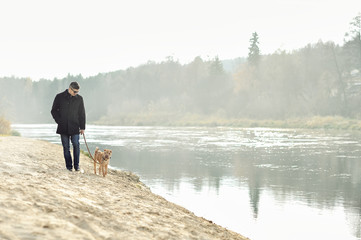 Man walking with dog near the river