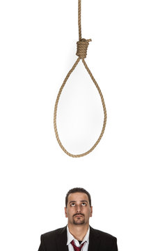 Businessman below a hangmans noose