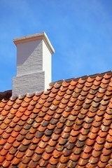 old tiles red roof with himney sky background