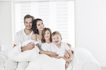 Obraz premium happy family having fun in the morning in parent's bed