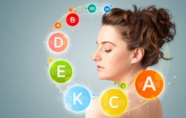 Pretty young girl with colorful vitamin icons and symbols