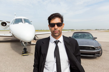 Entrepreneur In Front Of Car And Private Jet
