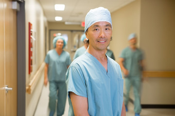 Doctor With Medical Team Walking In Hospital Corridor
