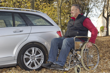 Naklejka premium Man in a wheelchair in the fall next to their car
