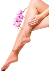 Obraz na płótnie Canvas female legs and pink manicure with orchid flower
