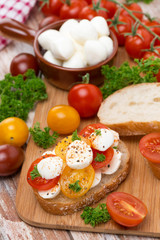 ciabatta with mozzarella and colorful cherry tomatoes on board