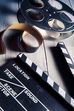 movie slate and film reel on wood