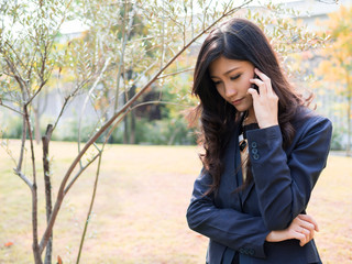 Businesswoman making a phone call in the garden