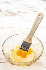 Wooden brush dipped into the whisked egg