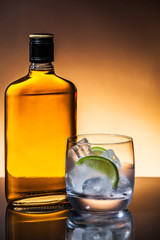 Glass and bottle of hard liquor like scotch, bourbon, whiskey or