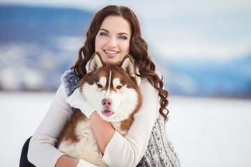 Girl embracing cute siberian husky in winter park