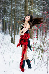 Beautiful woman with bright tinsel in winter forest