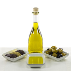 Olive oil in glass bottle and dished olive products