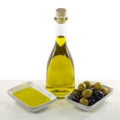 Olive oil in glass bottle and dish, and olives snack