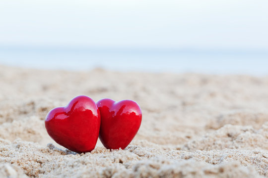 Two red hearts on the beach symbolizing love, Valentine's Day