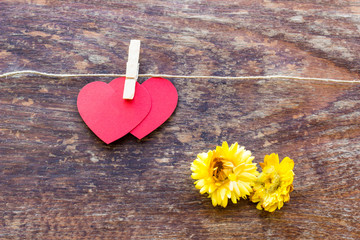 Valentine's day card with two red hearts symbol on a wooden  sur