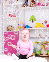 Obraz na płótnie Canvas Baby girl playing with soap bubbles
