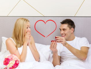 man giving woman little red box and ring in it