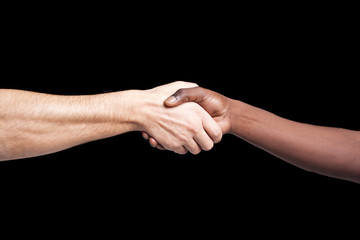 Handshake between african and a caucasian man against dark backg