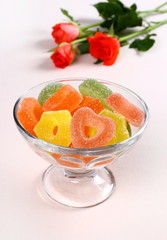 Colored candies with red hearts in glass bowl