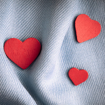 Valentine's day background. Red hearts on gray folds cloth
