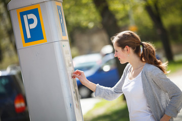 Young woman paying for parking