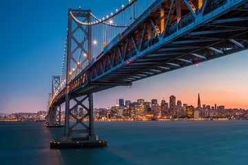 Abwaschbare Fototapete San Francisco Skyline von San Francisco umrahmt von der Bay Bridge bei Sonnenuntergang