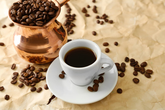 Cup and pot of coffee on beige background