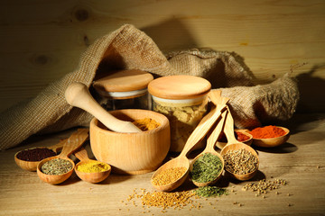 Assortment of spices in wooden spoons and jars,