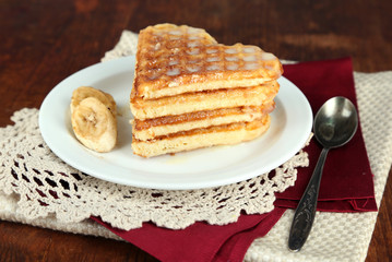 Sweet Belgium waffles with banana, on wooden table background