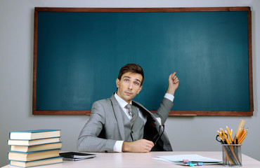 Young teacher sitting in school classroom