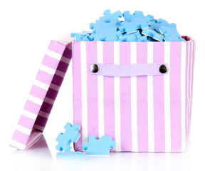 Textile box with puzzles, isolated on white