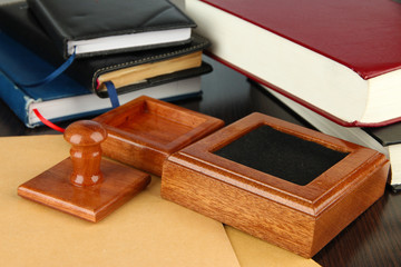 Wooden stamp with notepads  and books on table