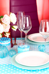 Table serving with colorful tableware on room background