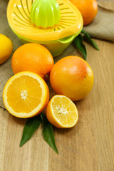 Citrus press and fruits on wooden background