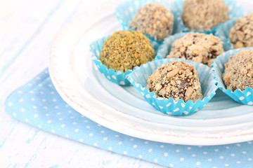 Set of chocolate candies, on plate, on wooden background