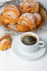Coffee with fresh croissants on wooden table still life