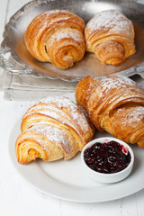 Fresh croissants with jam and sugar powder