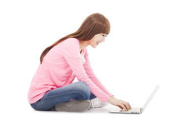 Smiling young woman sitting and typing on a laptop
